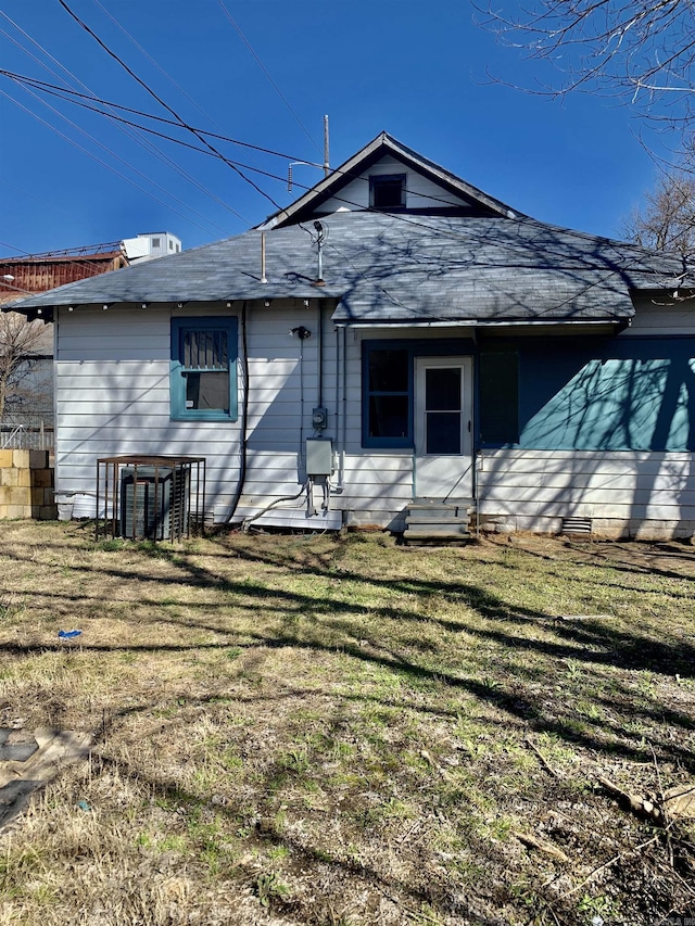 rear view of property with a lawn