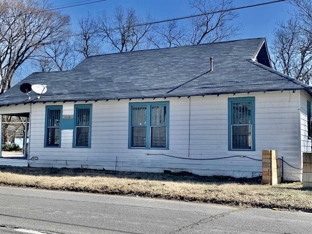 view of property exterior featuring a shingled roof and crawl space