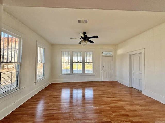 unfurnished room with visible vents, ceiling fan, baseboards, and wood finished floors