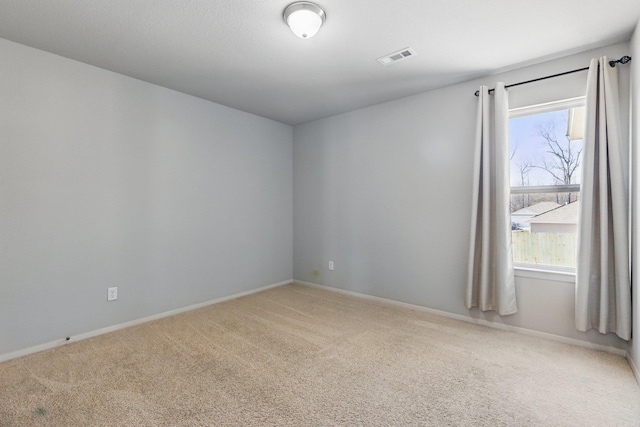 unfurnished room with light colored carpet, visible vents, and baseboards