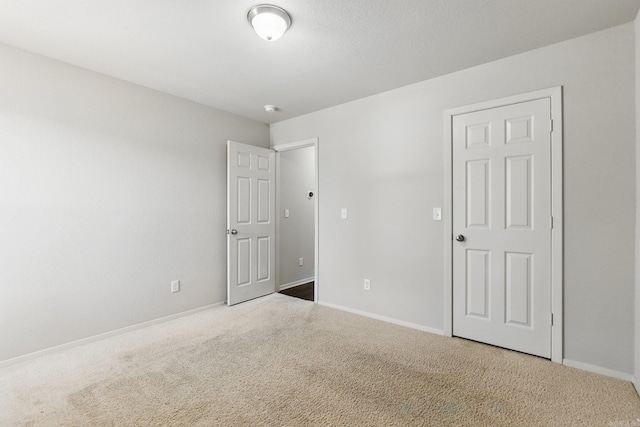 spare room with carpet and baseboards