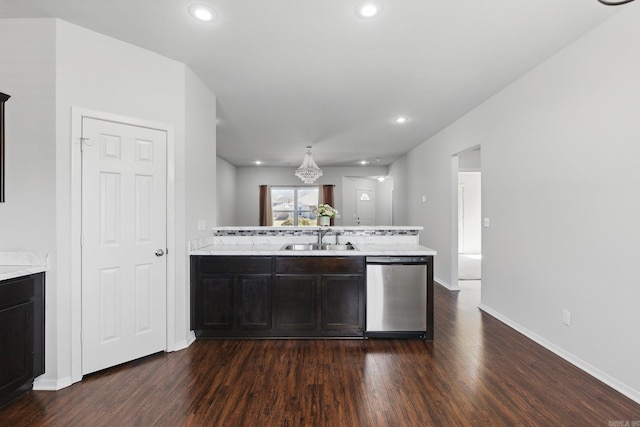 kitchen featuring light countertops, stainless steel dishwasher, dark wood-type flooring, a sink, and a peninsula