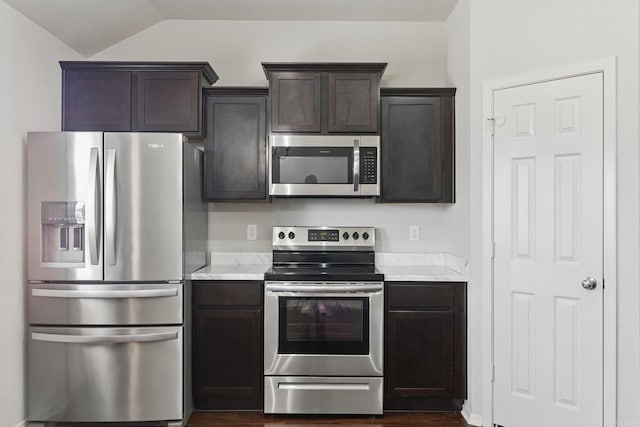 kitchen featuring lofted ceiling, dark brown cabinetry, stainless steel appliances, and light countertops