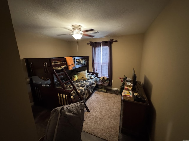 bedroom featuring ceiling fan, visible vents, and a textured ceiling