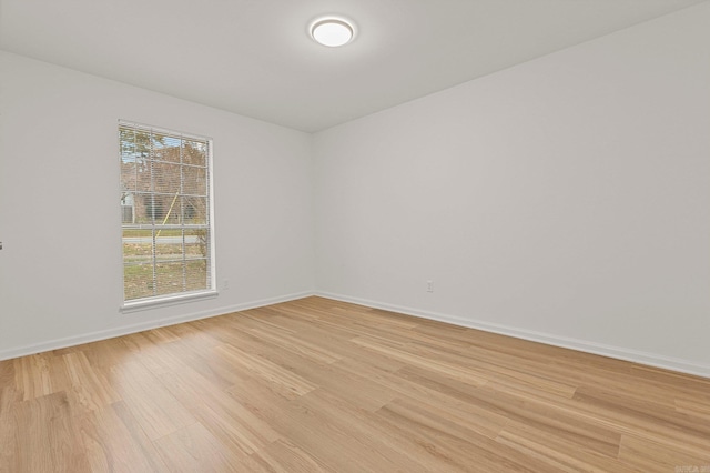 spare room with light wood-style flooring and baseboards