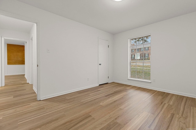 empty room featuring light wood-style flooring and baseboards