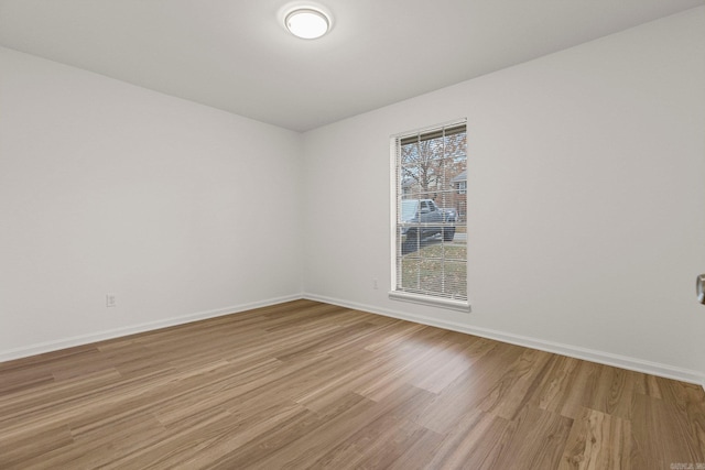 unfurnished room featuring light wood finished floors and baseboards