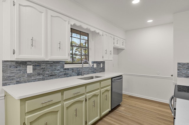 kitchen with light wood-style flooring, a sink, stainless steel appliances, light countertops, and backsplash