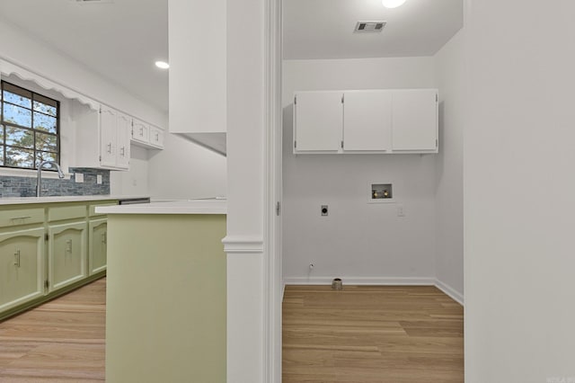 kitchen with light countertops, visible vents, light wood finished floors, and green cabinets