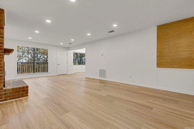 unfurnished living room with light wood-type flooring, a fireplace, visible vents, and recessed lighting