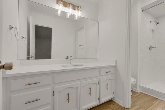 bathroom featuring vanity, a shower stall, toilet, and wood finished floors