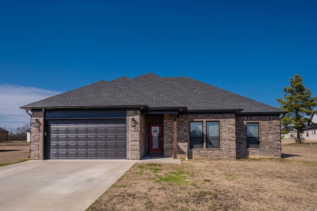 view of front of house with a garage, a shingled roof, brick siding, driveway, and a front lawn