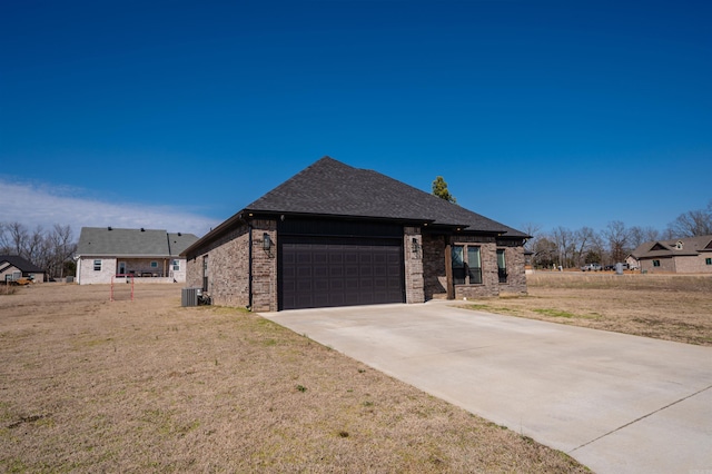 view of front of property featuring concrete driveway, central AC, brick siding, and an attached garage