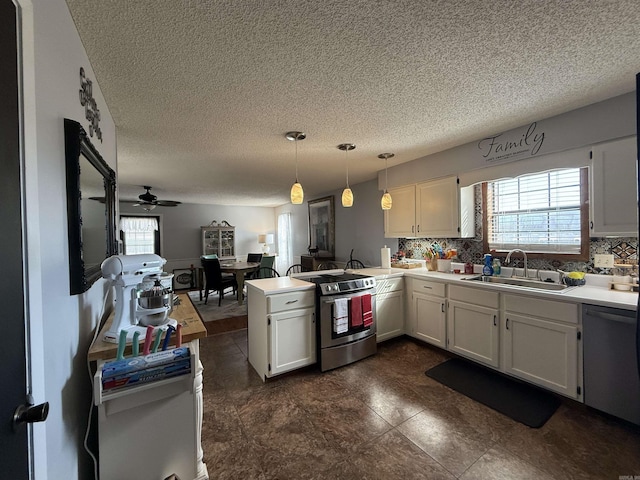 kitchen with stainless steel appliances, a healthy amount of sunlight, a sink, and a peninsula