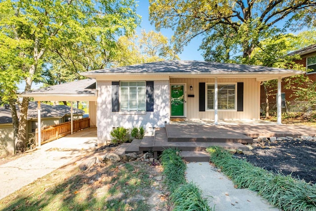 view of front of property with driveway, a porch, roof with shingles, and fence