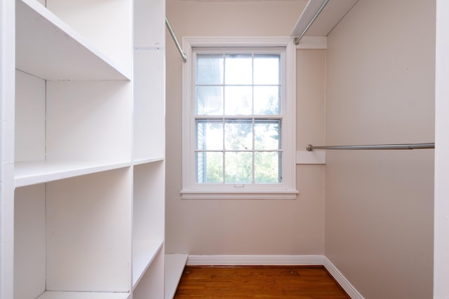 walk in closet with wood finished floors