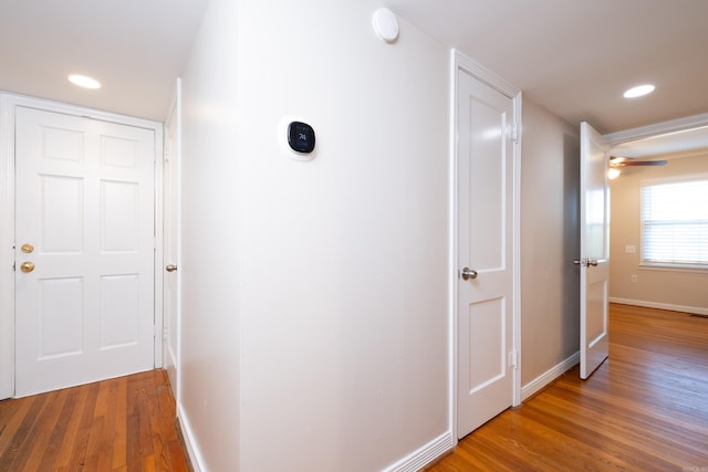 corridor with recessed lighting, baseboards, and wood finished floors