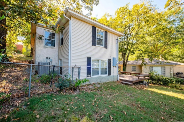 rear view of property with central AC, fence, a lawn, and a wooden deck