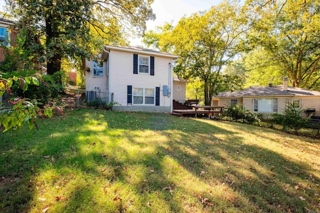 back of property featuring fence, a lawn, and a wooden deck