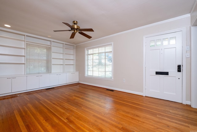 foyer featuring light wood-style floors, visible vents, baseboards, and crown molding