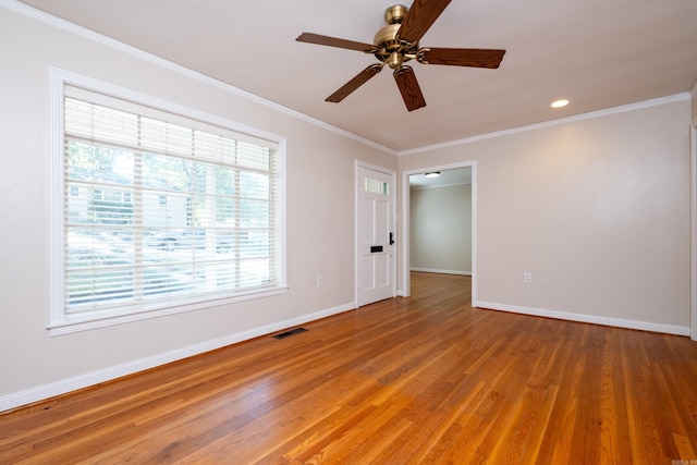 spare room with visible vents, crown molding, light wood finished floors, and baseboards