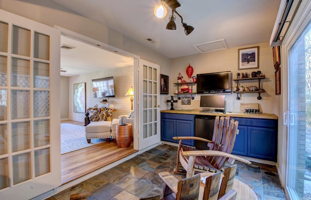 bar featuring stone finish flooring, visible vents, and french doors