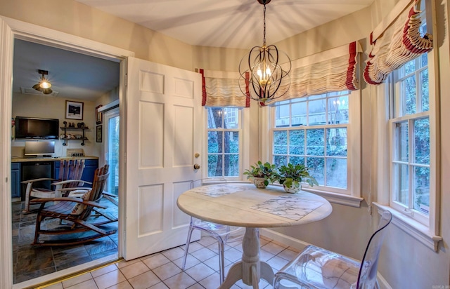 dining space with a chandelier, light tile patterned floors, and baseboards