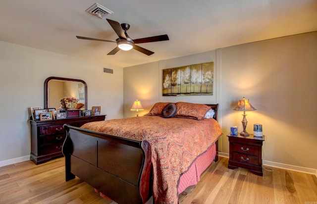 bedroom with light wood-style floors, baseboards, visible vents, and a ceiling fan