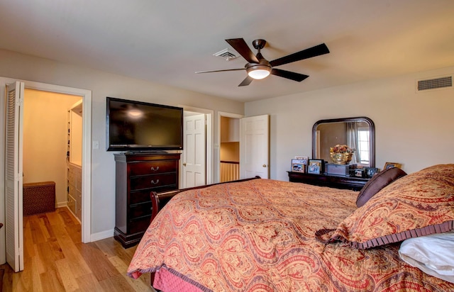 bedroom featuring light wood-style floors, baseboards, visible vents, and a ceiling fan
