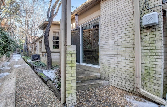 view of home's exterior with central AC and brick siding