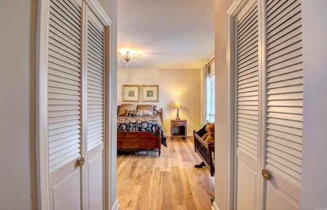 bedroom featuring light wood-style flooring, baseboards, and a closet