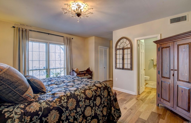 bedroom featuring light wood-type flooring, ensuite bath, visible vents, and baseboards