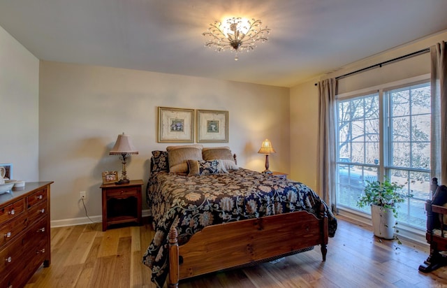 bedroom with light wood-style flooring and baseboards