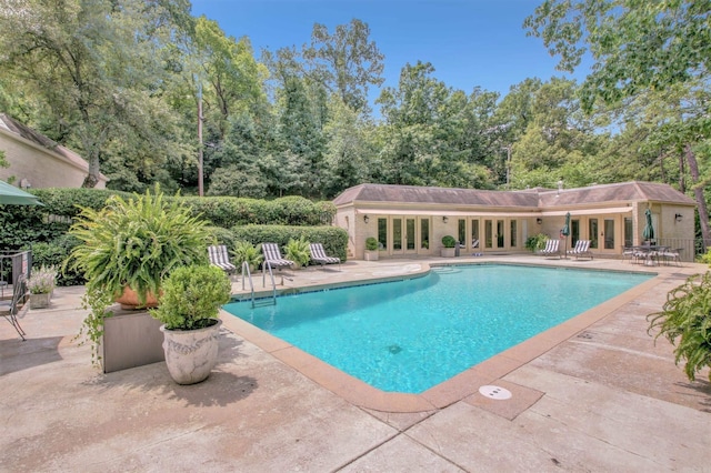 pool with french doors and a patio area