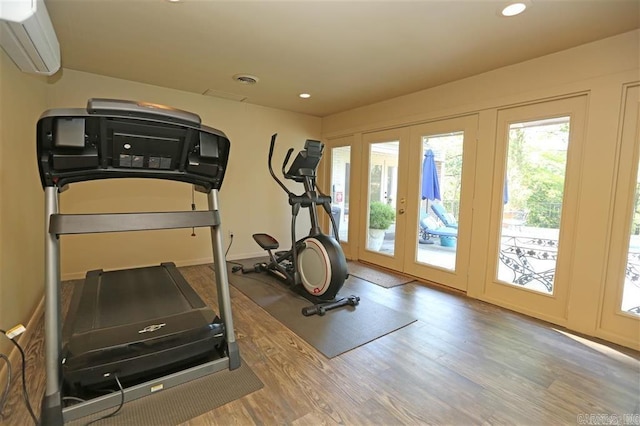 exercise room with recessed lighting, french doors, wood finished floors, and an AC wall unit
