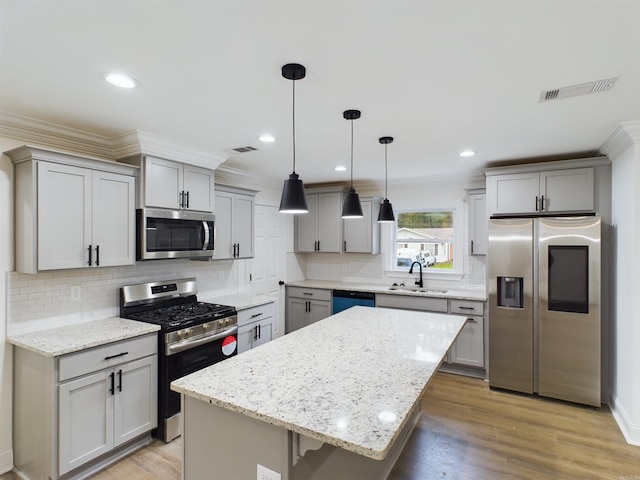 kitchen featuring ornamental molding, appliances with stainless steel finishes, a sink, and visible vents