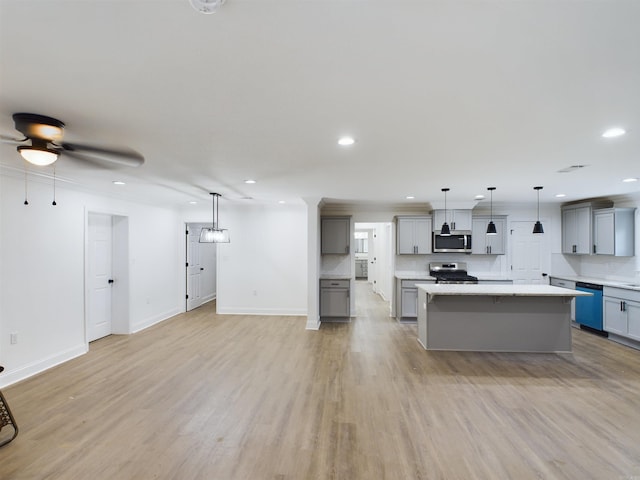 kitchen with a kitchen island, stainless steel appliances, gray cabinets, light wood-type flooring, and backsplash