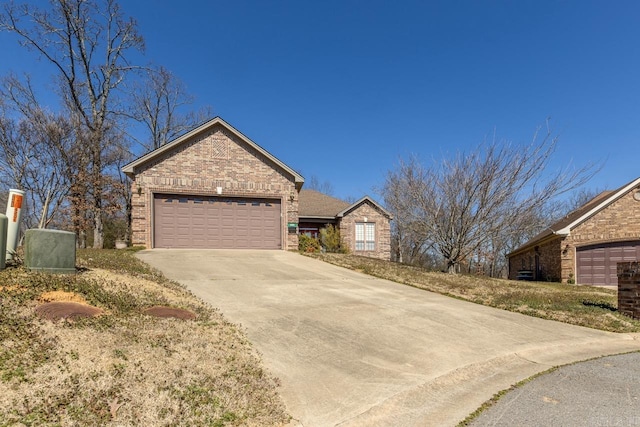 view of front of property featuring a garage, concrete driveway, and brick siding