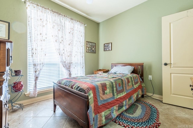 bedroom featuring light tile patterned floors and baseboards