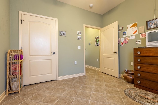 tiled bedroom featuring baseboards