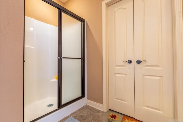 bathroom featuring a shower stall, baseboards, and tile patterned floors