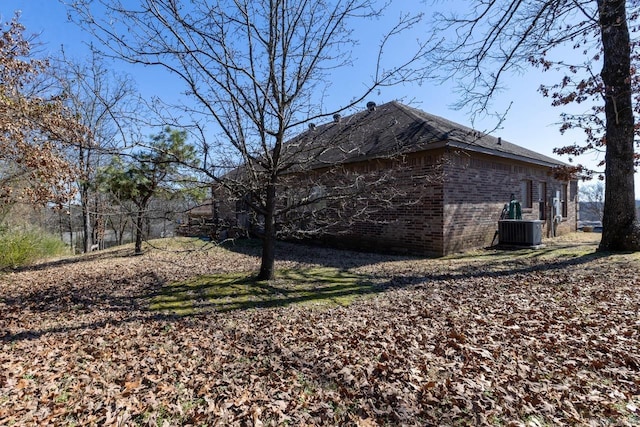 view of side of home featuring brick siding and cooling unit