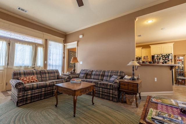 living area with light tile patterned floors, a ceiling fan, visible vents, and crown molding