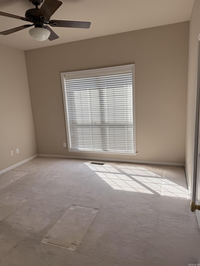 unfurnished room featuring visible vents, baseboards, a ceiling fan, and light colored carpet