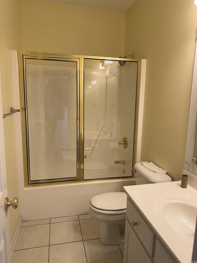 full bath with toilet, combined bath / shower with glass door, tile patterned flooring, and vanity