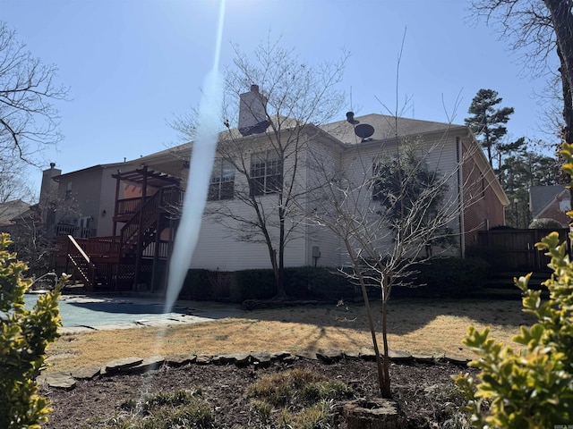 back of property with stairs and a chimney