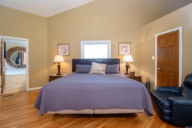 bedroom featuring light wood-style flooring, visible vents, and baseboards