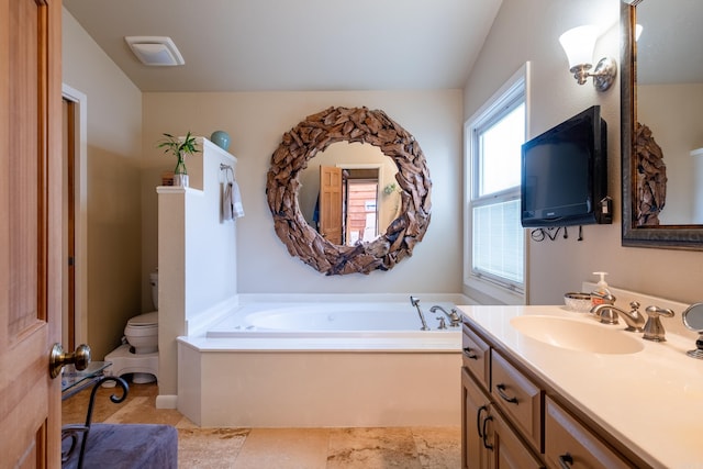 bathroom with vanity, a garden tub, and toilet