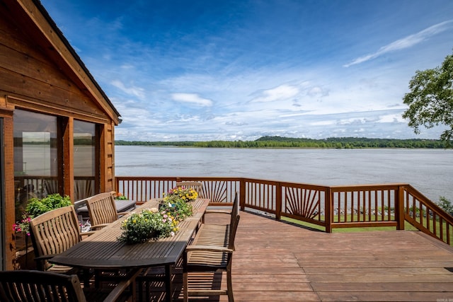 wooden deck with a water view and outdoor dining space