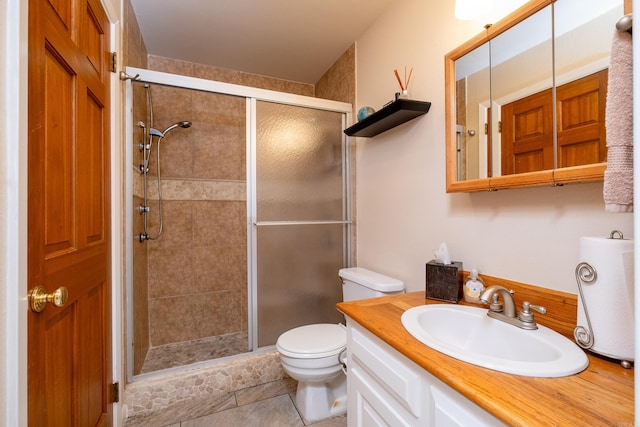 bathroom featuring a stall shower, vanity, toilet, and tile patterned floors